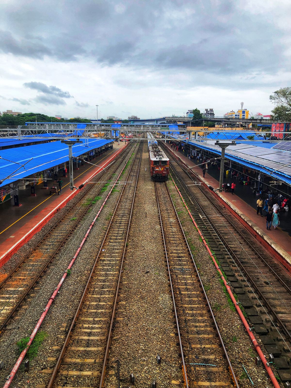 Aerial view of a passenger train at a busy railway station platform