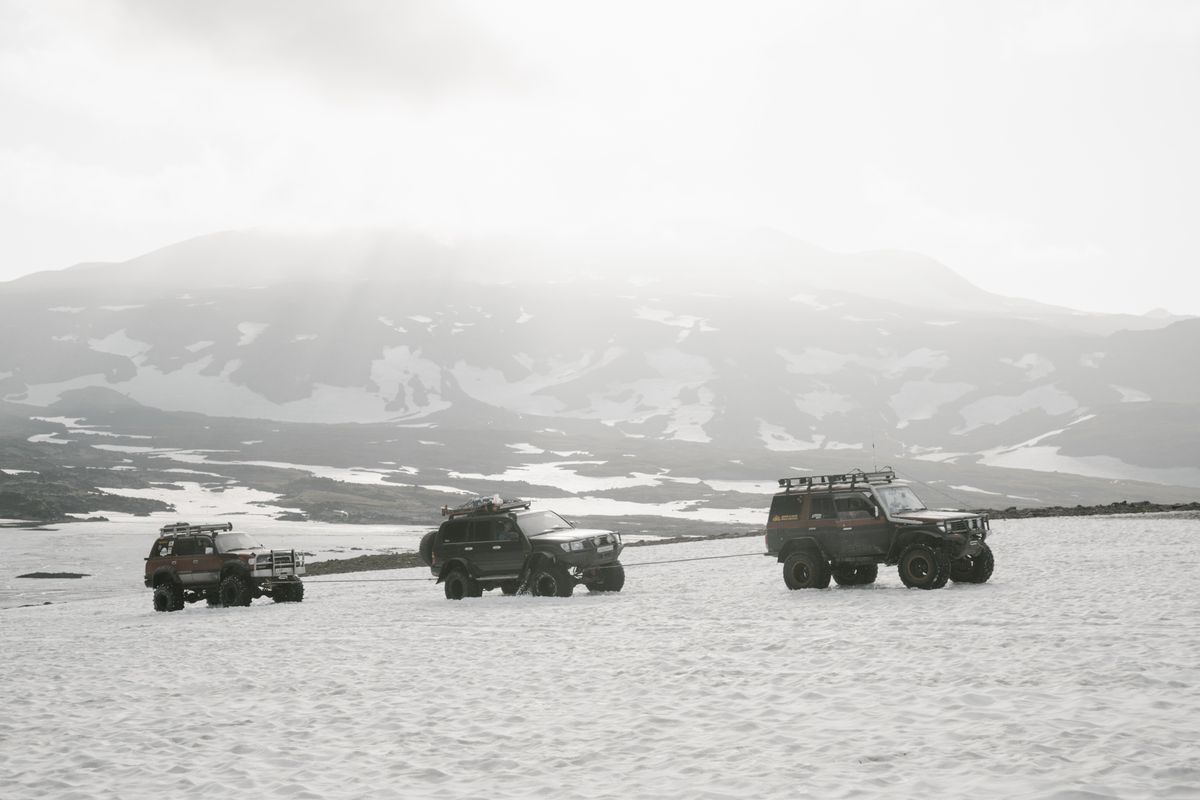 4x4 SUVs driving through a snow-covered mountain landscape on a winter safari